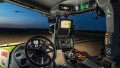 Einblick in die Fahrerkabine eines Traktors bei Nacht in dem das Bedienterminal CEBIS zu sehen ist.