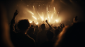 Eine tanzende Gruppe von Menschen bei einem Rock-Konzert. Warmes helles Licht beleuchtet die Band und die Fans in einer großen abgedunkelten Halle.