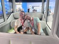 Two persons smiling and sitting close to each other in an autonomous driven car.