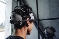 A person is wearing a head mounted device - possibly a brain computer interface.
